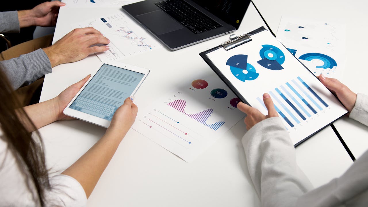 services-02 Team analyzing financial charts and digital reports during a business meeting.